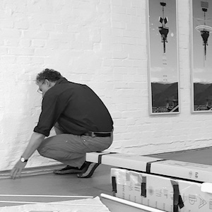 Rolf Blume misst eine Leiste am Boden